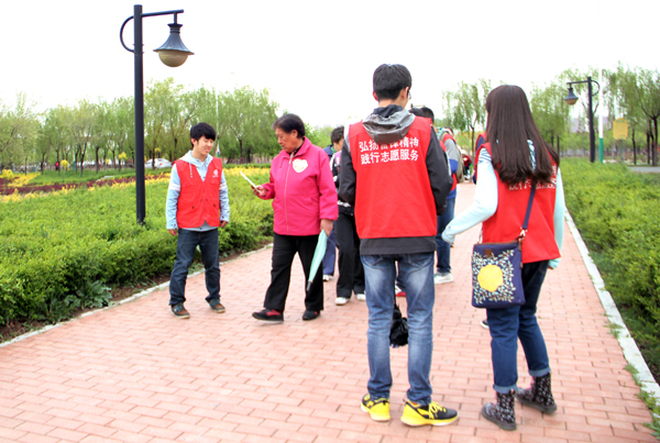 我院志愿者为参加活动的妈妈们发放环保书籍 动科院 记者 杨可心 摄